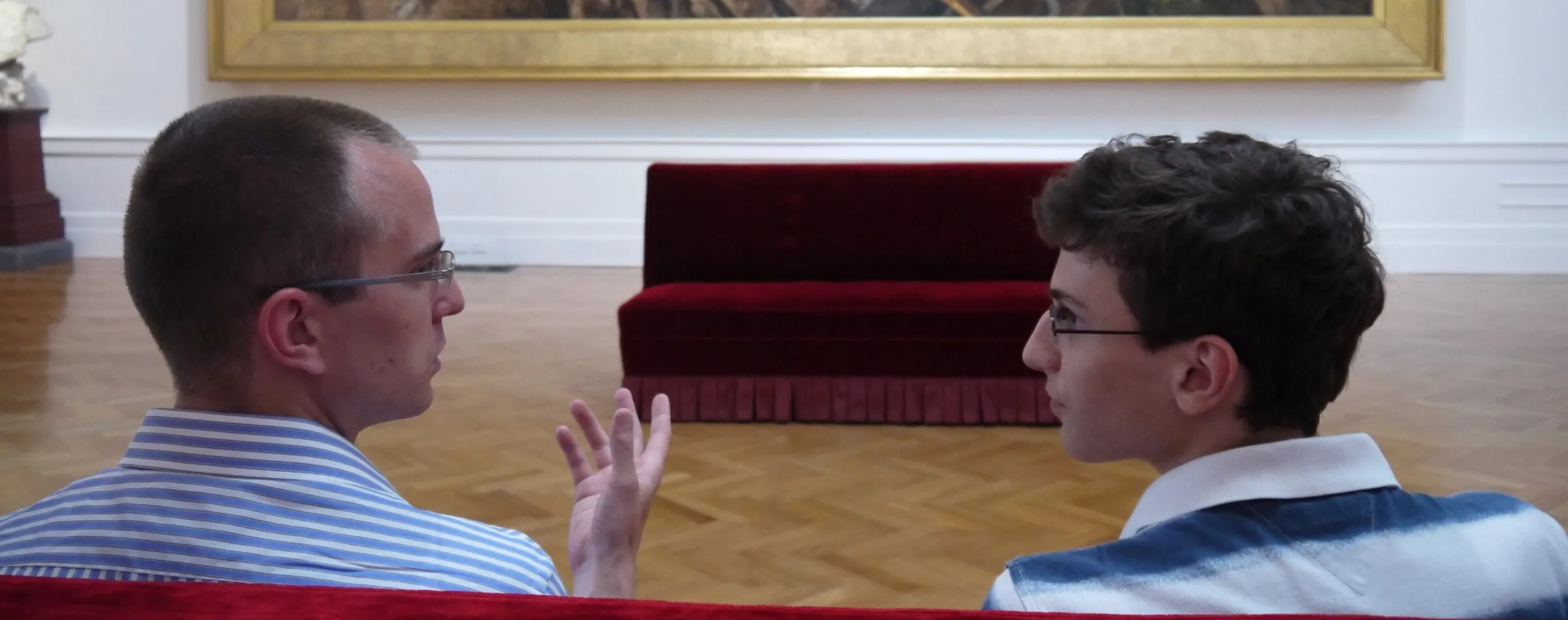 Zwei Männer im Gespräch in einem hellen Saal